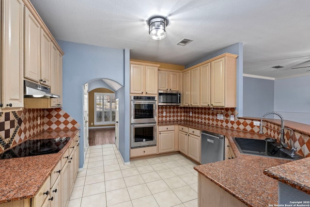 kitchen with visible vents, appliances with stainless steel finishes, stone counters, under cabinet range hood, and a sink