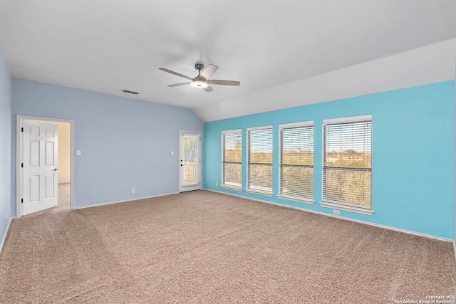 spare room with carpet floors, ceiling fan, visible vents, and vaulted ceiling