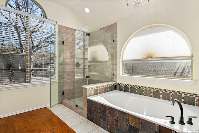 bathroom featuring lofted ceiling, a stall shower, a garden tub, and tile patterned floors