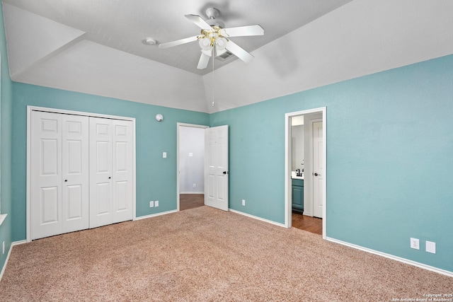 unfurnished bedroom with carpet, a closet, a ceiling fan, vaulted ceiling, and baseboards