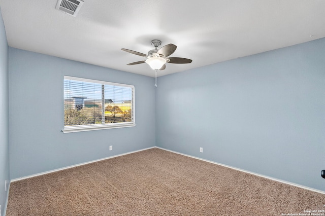 carpeted empty room with a ceiling fan, visible vents, and baseboards