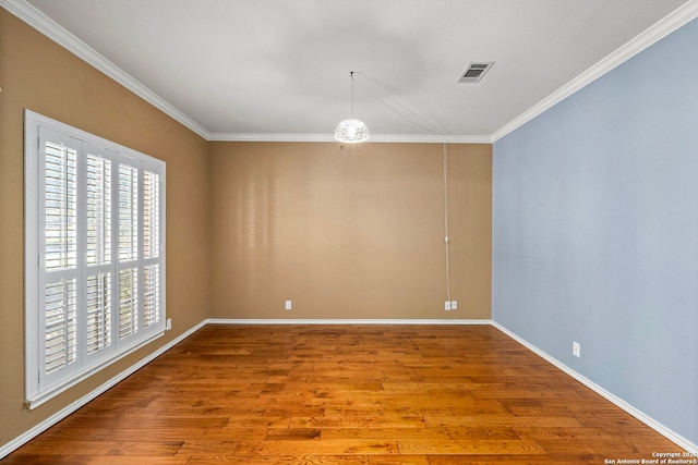 unfurnished room with light wood-type flooring, visible vents, crown molding, and baseboards