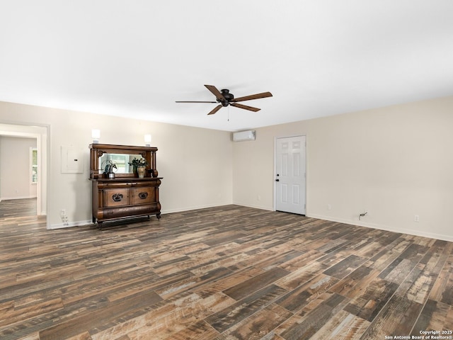 interior space featuring ceiling fan, dark wood finished floors, baseboards, and a wall mounted AC