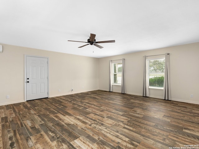 unfurnished room with a ceiling fan, baseboards, and dark wood-type flooring