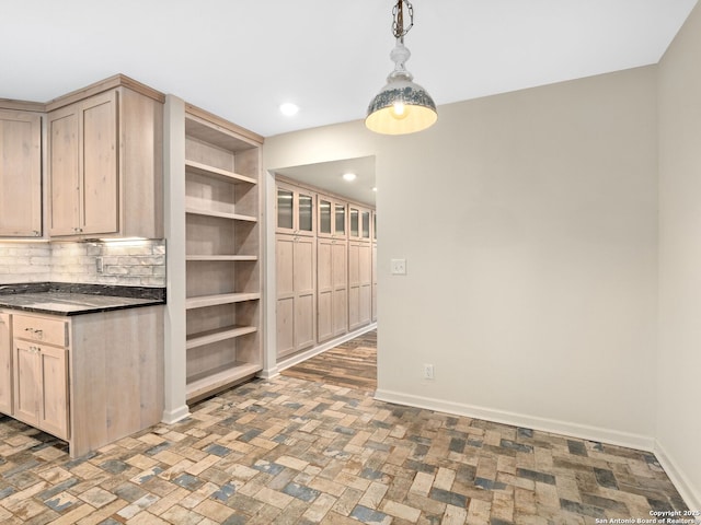 kitchen with dark countertops, baseboards, open shelves, and light brown cabinetry