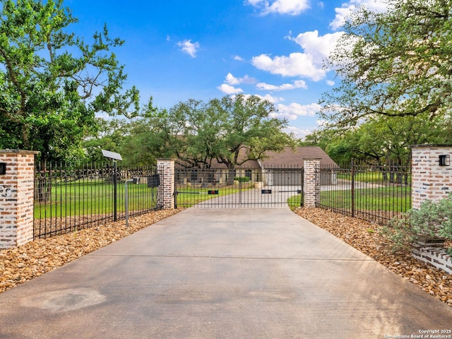 view of gate with a yard and fence