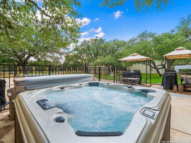 view of pool featuring a gazebo, fence, and a hot tub