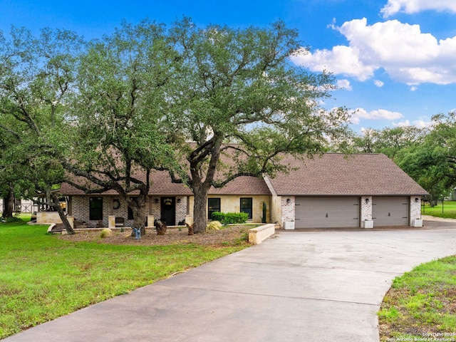 view of front of home with a garage, concrete driveway, a front lawn, and roof with shingles