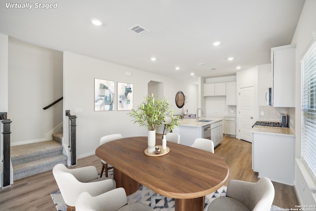 dining area featuring light wood-style floors, stairs, visible vents, and recessed lighting