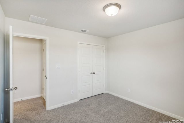 unfurnished bedroom with a closet, carpet, visible vents, and baseboards