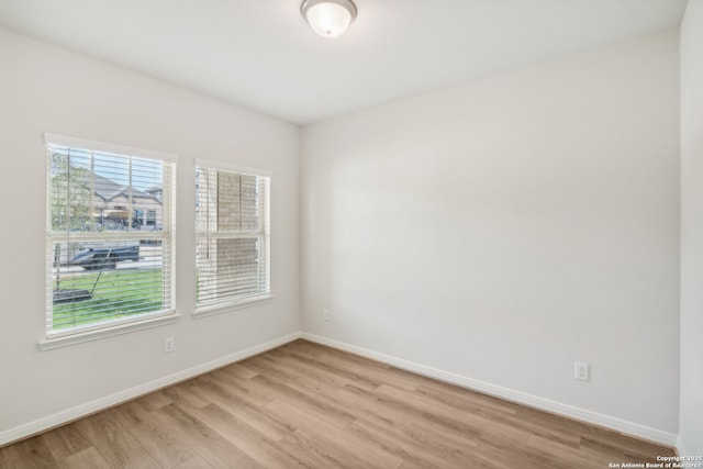 spare room with light wood-type flooring and baseboards