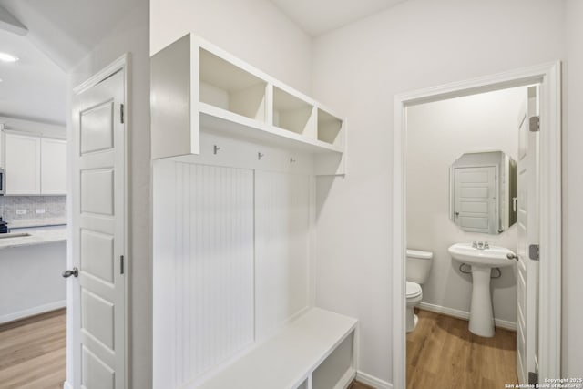 mudroom featuring light wood finished floors and baseboards