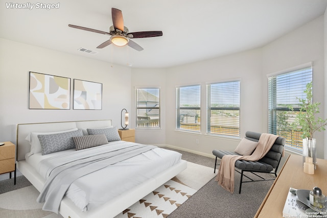 bedroom featuring baseboards, multiple windows, visible vents, and a ceiling fan