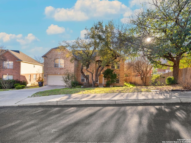 view of front of property with a garage, concrete driveway, brick siding, and fence