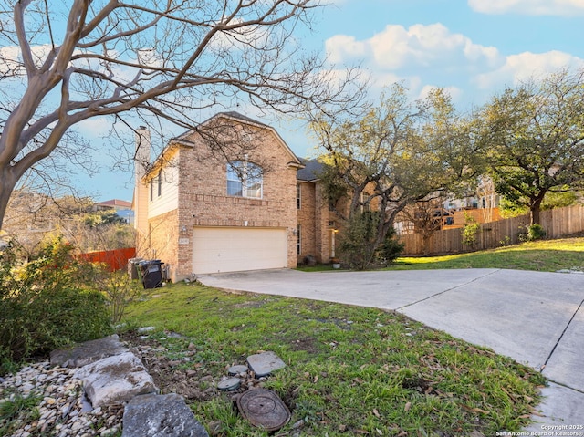 view of front of property with driveway, a chimney, fence, and brick siding