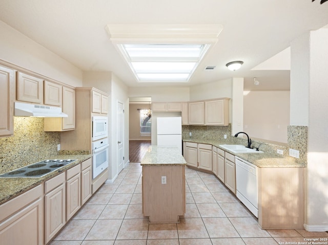 kitchen featuring white appliances, under cabinet range hood, a peninsula, and light tile patterned floors