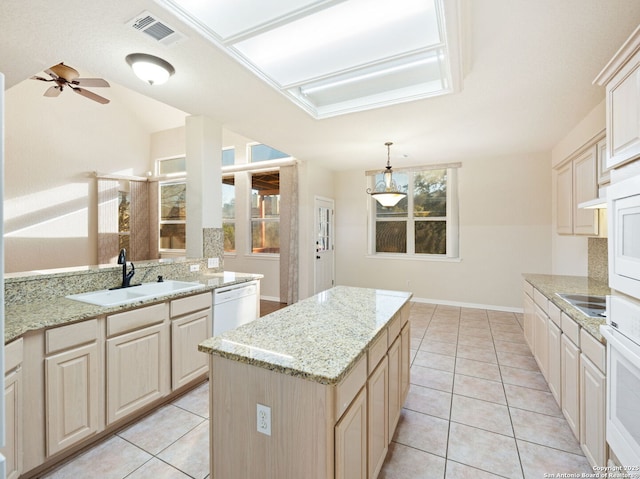 kitchen featuring a peninsula, a sink, visible vents, a center island, and pendant lighting