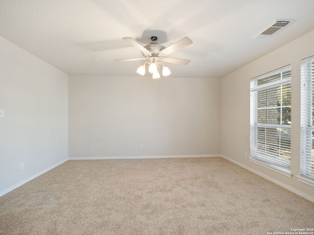 spare room with a ceiling fan, a textured ceiling, visible vents, and carpet flooring