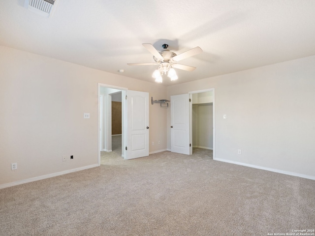 unfurnished bedroom featuring visible vents, light carpet, and baseboards