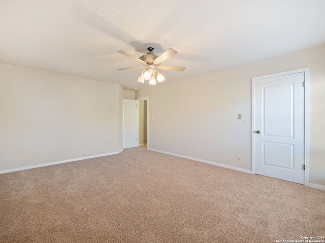 carpeted empty room featuring ceiling fan, a textured ceiling, and baseboards