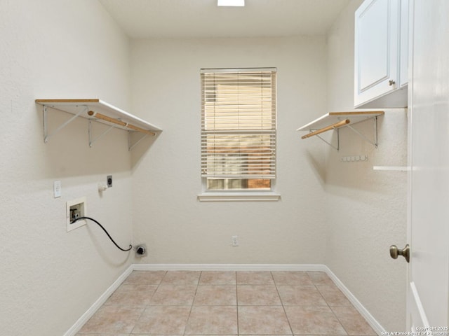 clothes washing area with hookup for a washing machine, light tile patterned floors, baseboards, and hookup for an electric dryer