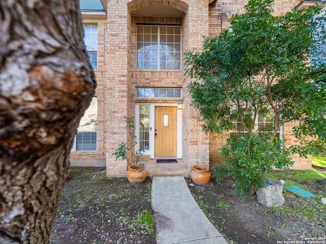 view of exterior entry with brick siding