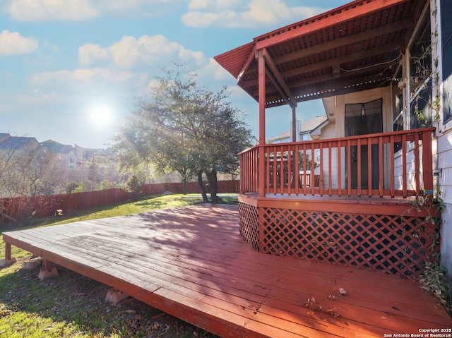 wooden terrace with a fenced backyard