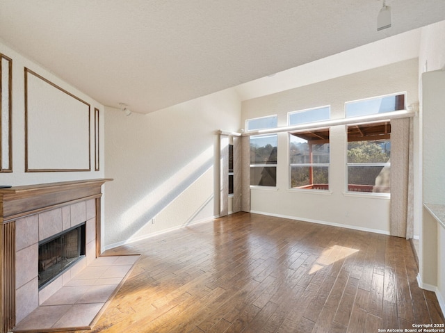 unfurnished living room with light wood-type flooring, a fireplace, and baseboards