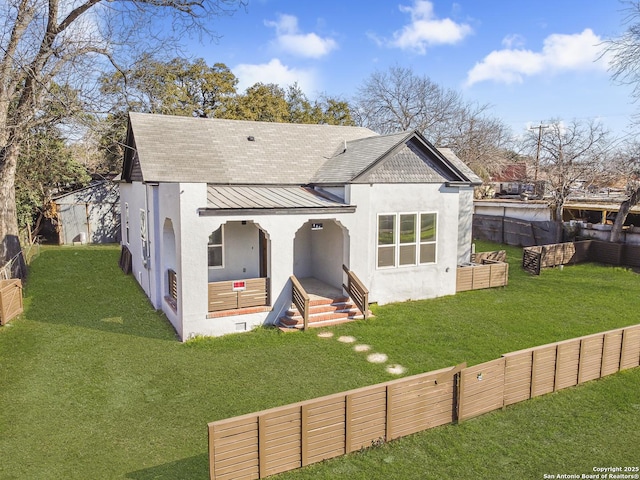 back of property with fence private yard, a standing seam roof, metal roof, and stucco siding