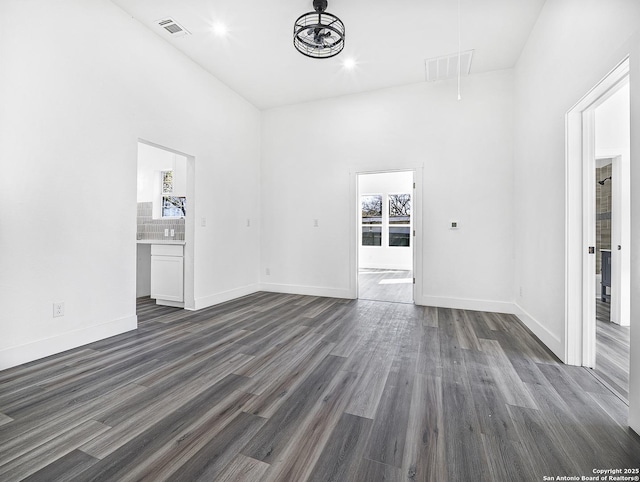 spare room featuring visible vents, dark wood-style floors, and attic access