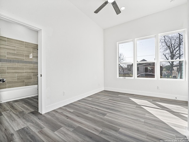 unfurnished bedroom with multiple windows, baseboards, dark wood-style flooring, and connected bathroom