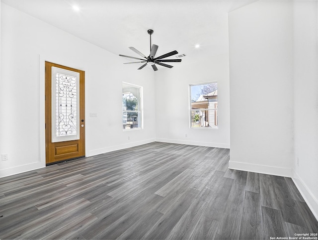 interior space featuring dark wood-style floors, a ceiling fan, and baseboards