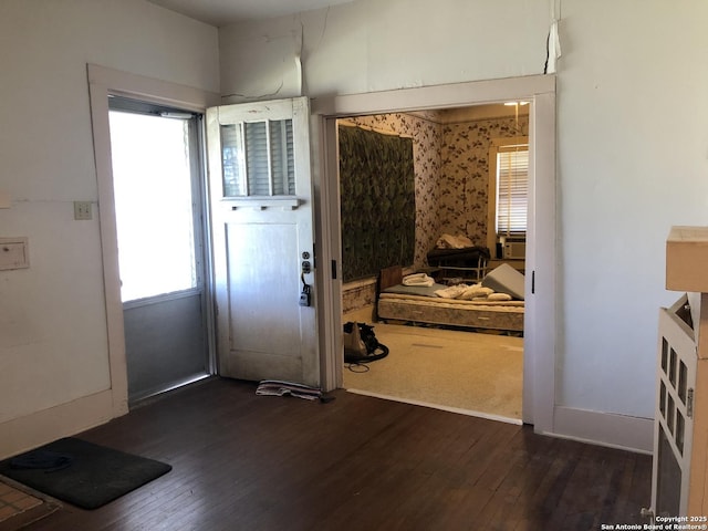 doorway to outside featuring dark wood finished floors and baseboards