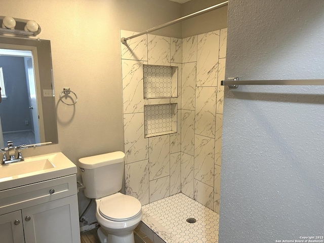 bathroom featuring toilet, a stall shower, and vanity