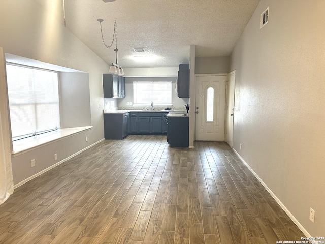 kitchen with visible vents, dark wood-style flooring, decorative light fixtures, light countertops, and a sink