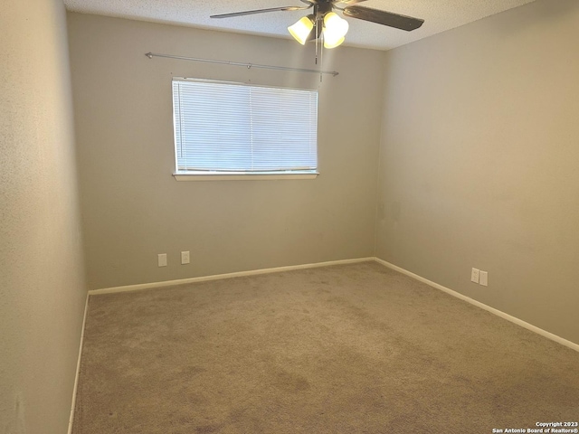 carpeted empty room with baseboards, a ceiling fan, and a textured ceiling