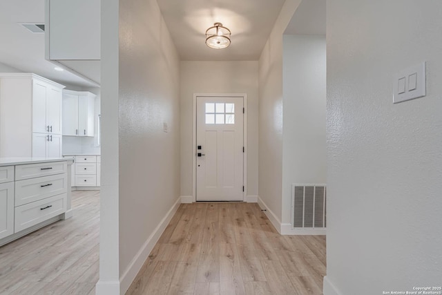 entryway featuring light wood-type flooring, visible vents, and baseboards