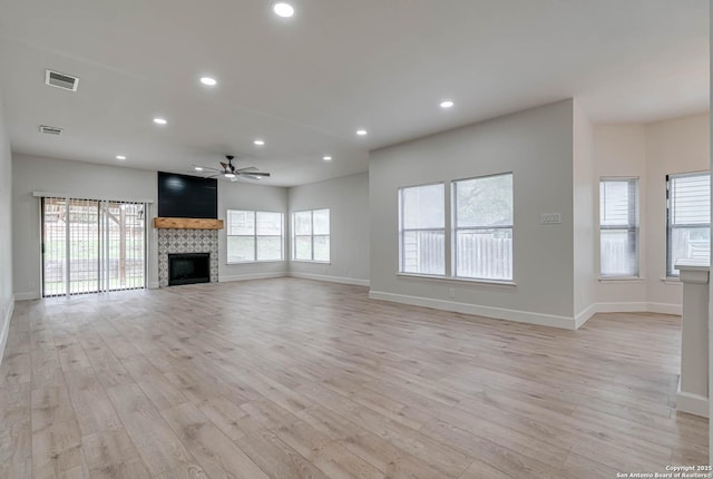 unfurnished living room with light wood finished floors, a fireplace, visible vents, and recessed lighting