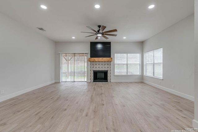 unfurnished living room with light wood finished floors, recessed lighting, a ceiling fan, and a tile fireplace