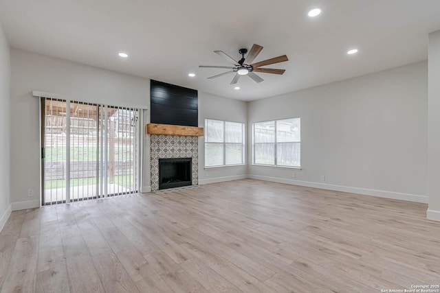 unfurnished living room featuring a fireplace, recessed lighting, ceiling fan, light wood-type flooring, and baseboards