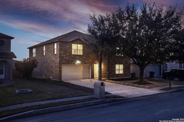 traditional home with driveway, a garage, and brick siding