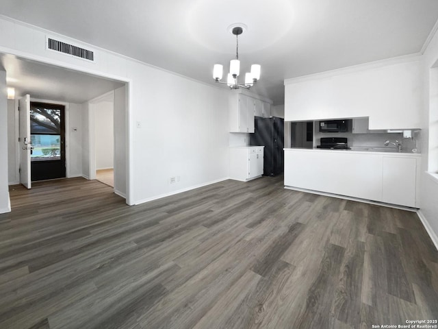 kitchen with black microwave, visible vents, white cabinets, light countertops, and an inviting chandelier