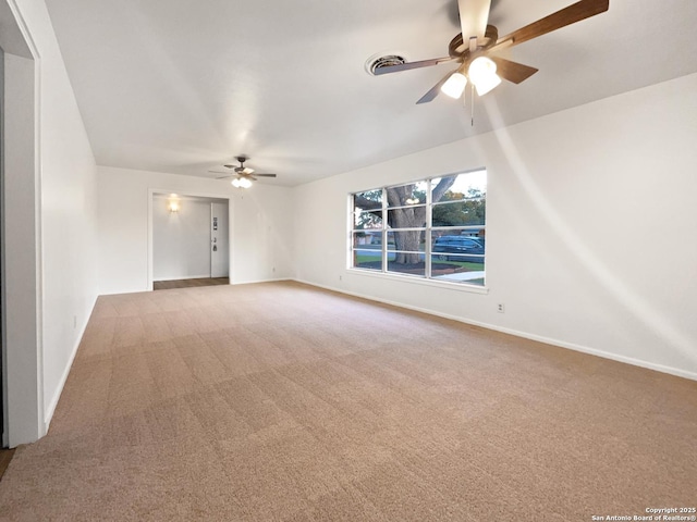 carpeted empty room featuring ceiling fan and baseboards