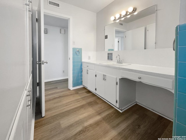 bathroom featuring tile walls, visible vents, vanity, and wood finished floors