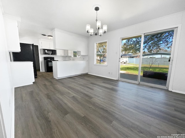 kitchen with white cabinets, open floor plan, light countertops, black appliances, and pendant lighting