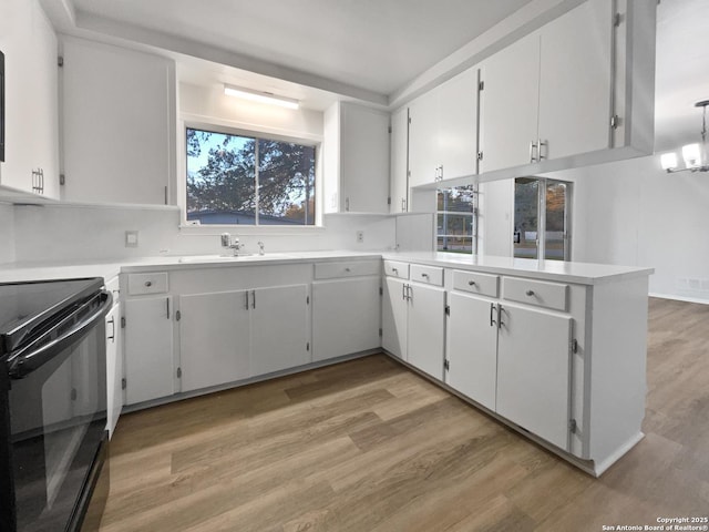 kitchen with white cabinets, black electric range oven, and light countertops