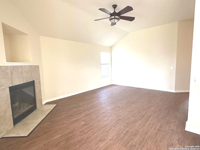 unfurnished living room with baseboards, a tiled fireplace, lofted ceiling, ceiling fan, and dark wood-style flooring