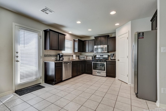 kitchen with light tile patterned floors, appliances with stainless steel finishes, visible vents, and dark brown cabinetry