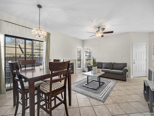 dining space featuring light tile patterned floors, a tile fireplace, and a wealth of natural light