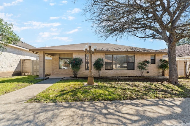 ranch-style house with fence, a front lawn, and brick siding